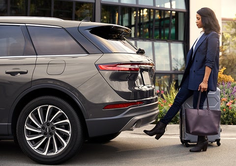 A woman with her hands full uses her foot to activate the available hands-free liftgate. | Griffin Lincoln in Tifton GA