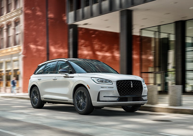The 2024 Lincoln Corsair® SUV with the Jet Appearance Package and a Pristine White exterior is parked on a city street. | Griffin Lincoln in Tifton GA