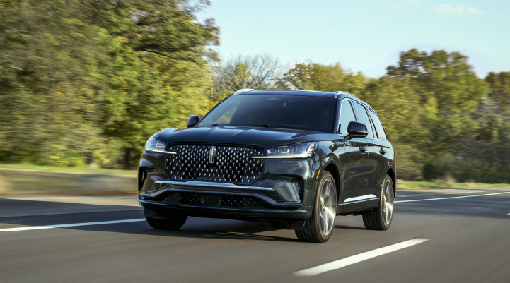 A 2025 Lincoln Black Label Aviator® SUV is being driven down a road lined with trees. | Griffin Lincoln in Tifton GA