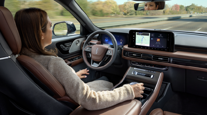 A woman is seen sitting in the driver’s seat of her 2025 Lincoln Aviator® SUV with her hands off the steering wheel. | Griffin Lincoln in Tifton GA