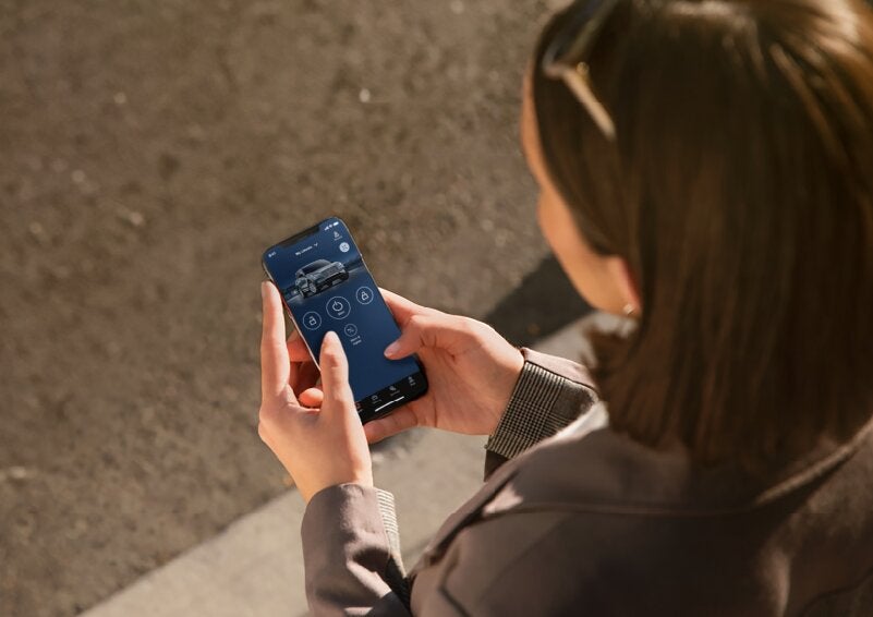 A person is shown interacting with a smartphone to connect to a Lincoln vehicle via the Lincoln Way® App. | Griffin Lincoln in Tifton GA