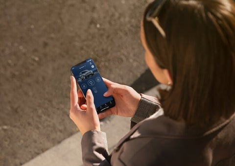 A person is shown interacting with a smartphone to connect to a Lincoln vehicle via the Lincoln Way® App. | Griffin Lincoln in Tifton GA
