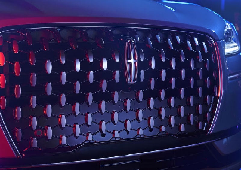 The grille of a 2025 Lincoln Corsair® SUV reflects neon light at night. | Griffin Lincoln in Tifton GA