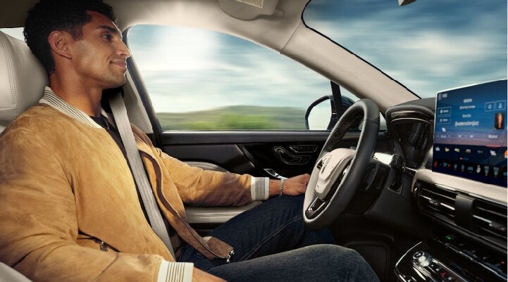 A person is shown using Lincoln BlueCruise hands-free highway driving technology on a divided highway called a Hands-Free Blue Zone. | Griffin Lincoln in Tifton GA