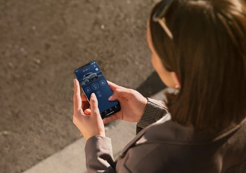A person is shown interacting with a smartphone to connect to a Lincoln vehicle via the Lincoln Way® app. | Griffin Lincoln in Tifton GA