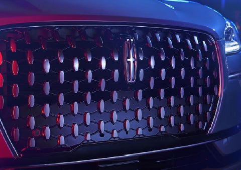 The grille of a 2025 Lincoln Corsair&reg; SUV reflects neon light at night. | Griffin Lincoln in Tifton GA