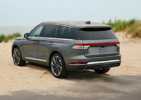 A 2027 Lincoln Aviator® SUV is parked next to sand dunes. | Griffin Lincoln in Tifton GA